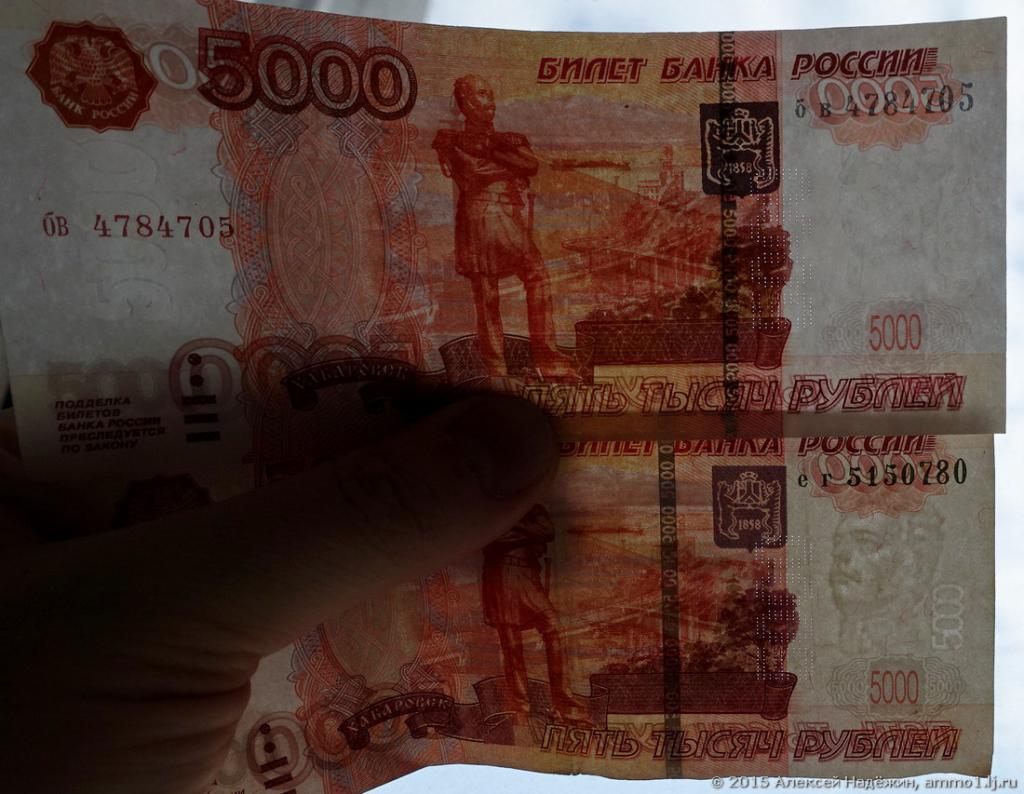 фальшивка и настоящая купюра на просвет